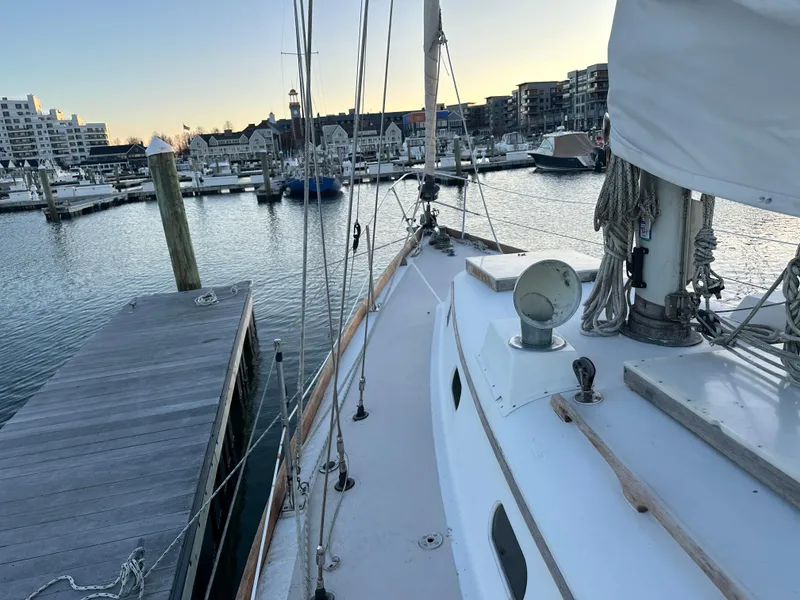 Slide: The Image of 1970 Hinckley 38 sailboat docked at a marina during sunset. - 14