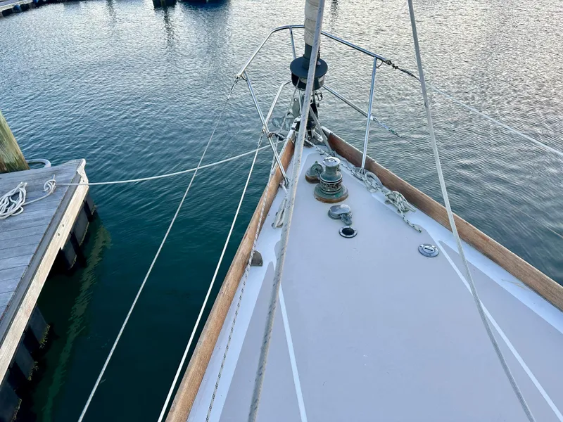 Slide: The Image of Bow of a 1970 Hinckley 38 sailboat docked at a marina. - 15
