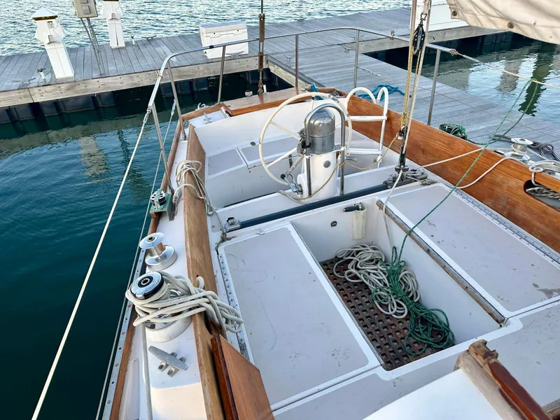 Slide: The Image of 1970 Hinckley 38 sailboat cockpit with ropes and steering wheel, docked at marina. - 21