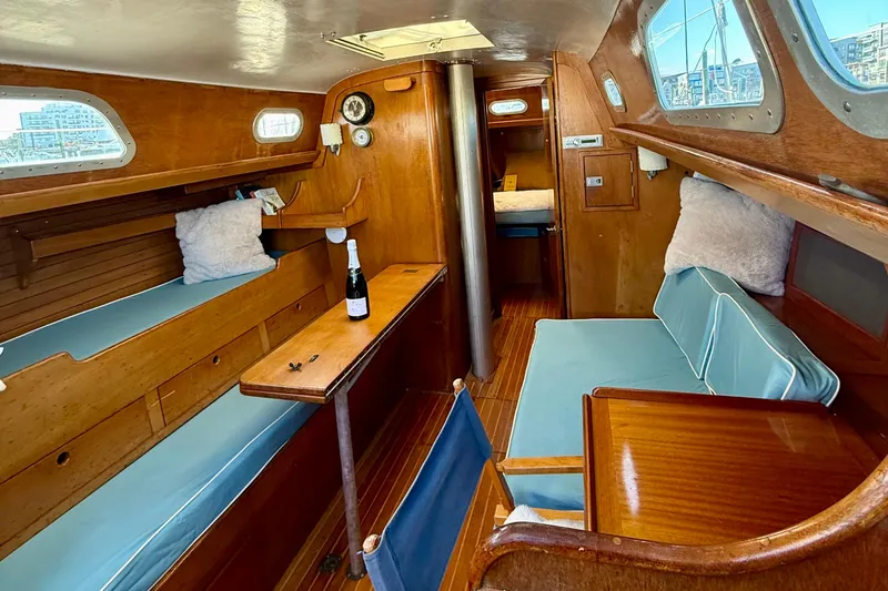 Slide: The Image of 1970 Hinckley 38 sailboat interior with wooden finish and blue seating. - 26