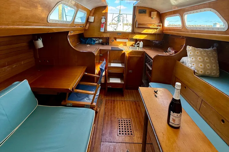 Slide: The Image of Interior of a 1970 Hinckley 38 sailboat with wooden furnishings and blue cushions. - 27