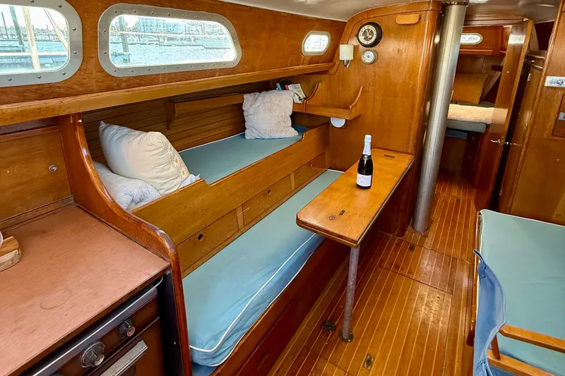Slide: The Image of 1970 Hinckley 38 sailboat interior with wooden furnishings and cozy seating area. - 28
