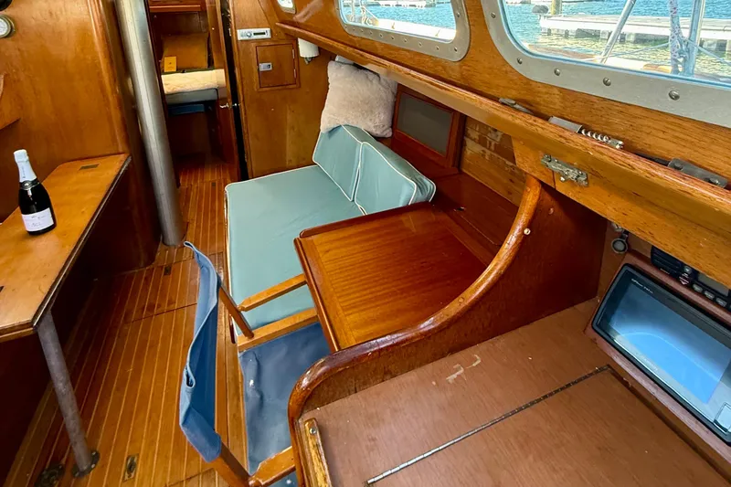 Slide: The Image of Interior of a 1970 Hinckley 38 sailboat with wooden furnishings and seating area. - 29
