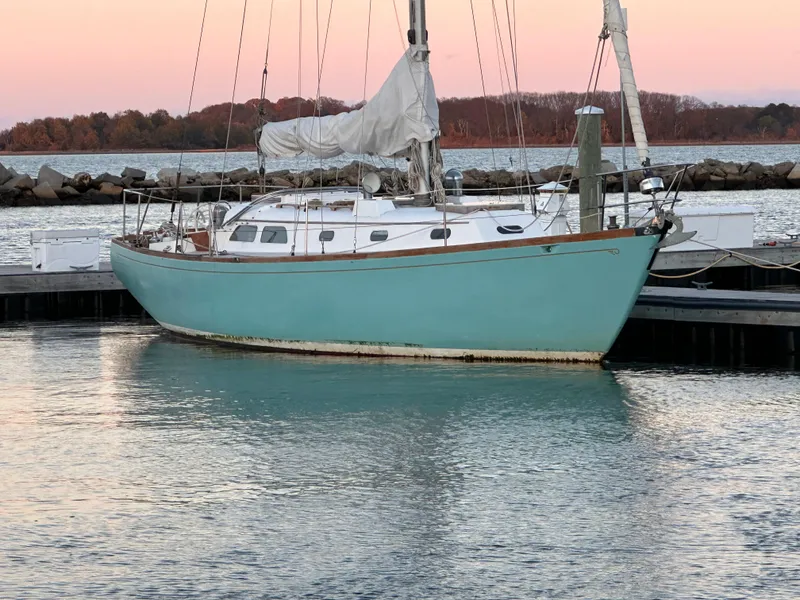 Slide: The Image of 1970 Hinckley 38 sailboat docked at sunset with calm waters. - 3
