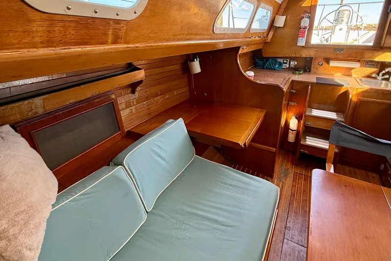 Slide: The Image of 1970 Hinckley 38 sailboat interior with wooden finish and cozy seating area. - 34