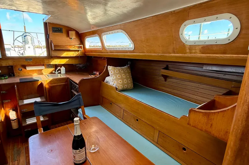 Slide: The Image of Interior of a 1970 Hinckley 38 sailboat with wooden furnishings and a cozy seating area. - 35