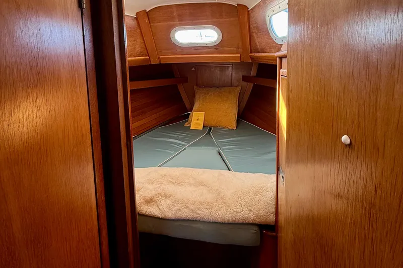 Slide: The Image of 1970 Hinckley 38 sailboat cabin interior with wooden finish and cozy bedding. - 37