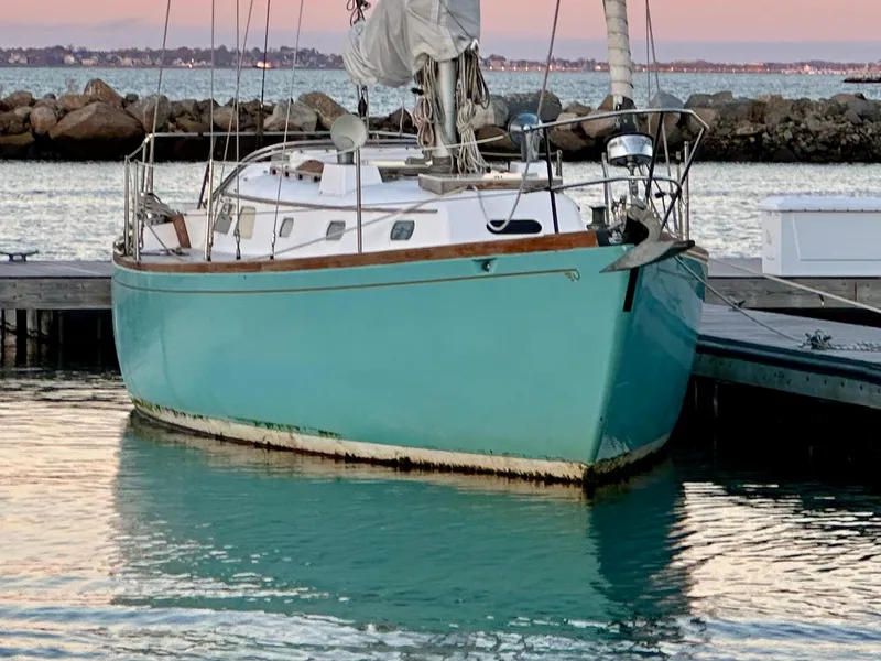 Slide: The Image of 1970 Hinckley 38 sailboat docked in a serene marina at sunset. - 4