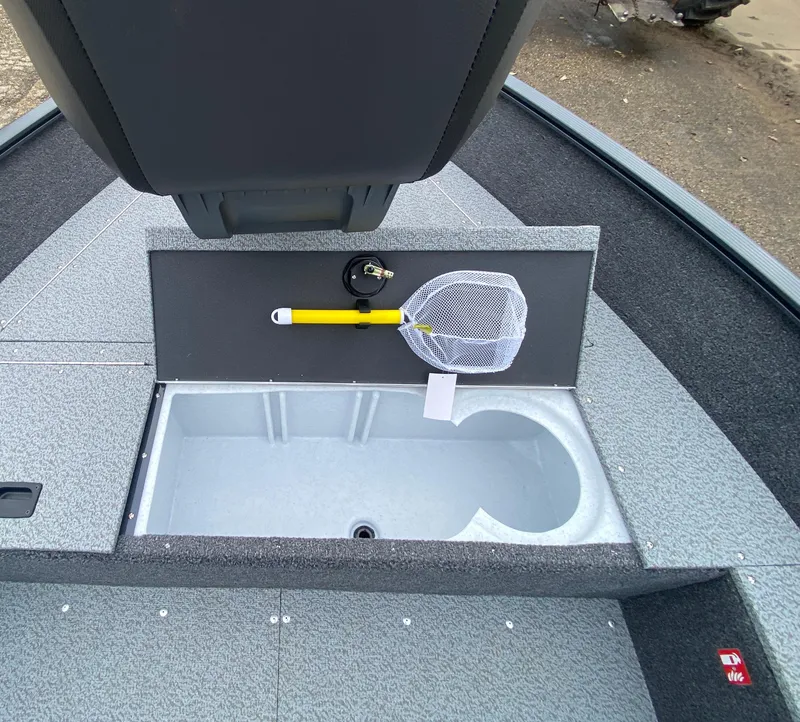 Slide: The Image of 2025 Lund 1650 Angler Tiller boat interior with storage compartment and fishing net. - 12