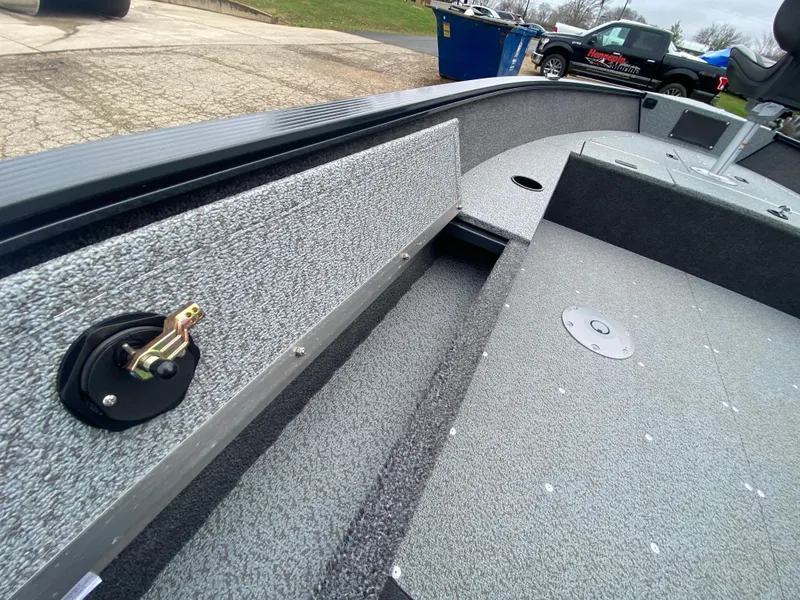 Slide: The Image of 2025 Lund 1650 Angler Tiller boat interior with textured flooring and storage compartments. - 19