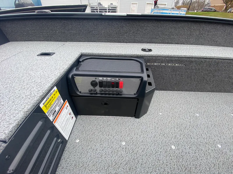 Slide: The Image of 2025 Lund 1650 Angler Tiller boat interior with control panel and storage compartment. - 20