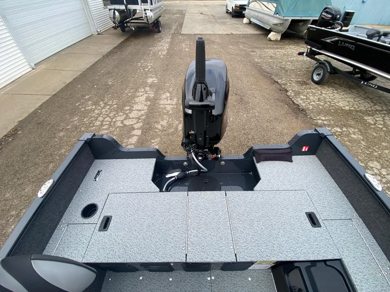 Slide: The Image of 2025 Lund 1650 Angler Tiller boat, rear view, showcasing spacious deck and motor. - 23