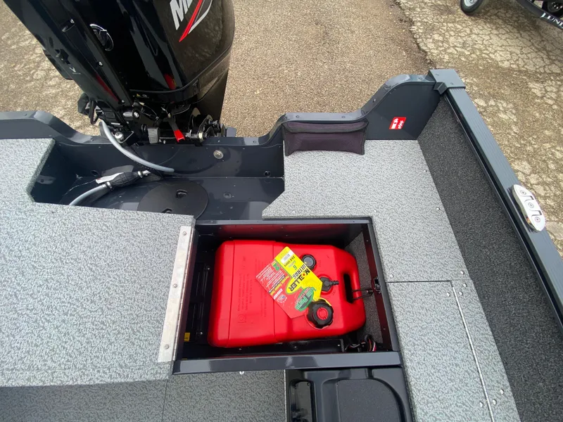 Slide: The Image of 2025 Lund 1650 Angler Tiller boat with open storage compartment and red fuel tank. - 24