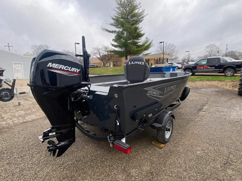 Slide: The Image of 2025 Lund 1650 Angler Tiller boat with Mercury engine, parked outdoors. - 3