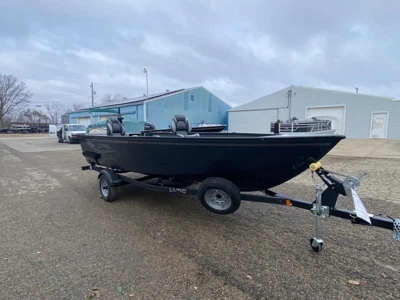 Slide: The Image of 2025 Lund 1650 Angler Tiller boat on trailer, parked outdoors. - 5
