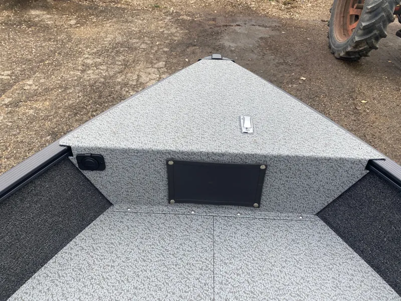 Slide: The Image of 2025 Lund 1650 Angler Tiller boat interior with textured flooring and storage compartment. - 9