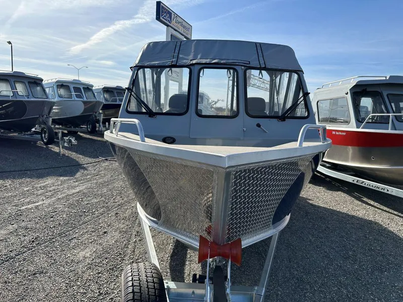 Slide: The Image of 2025 Hewescraft 210 Sea Runner ET boat displayed in a dealership lot. - 2