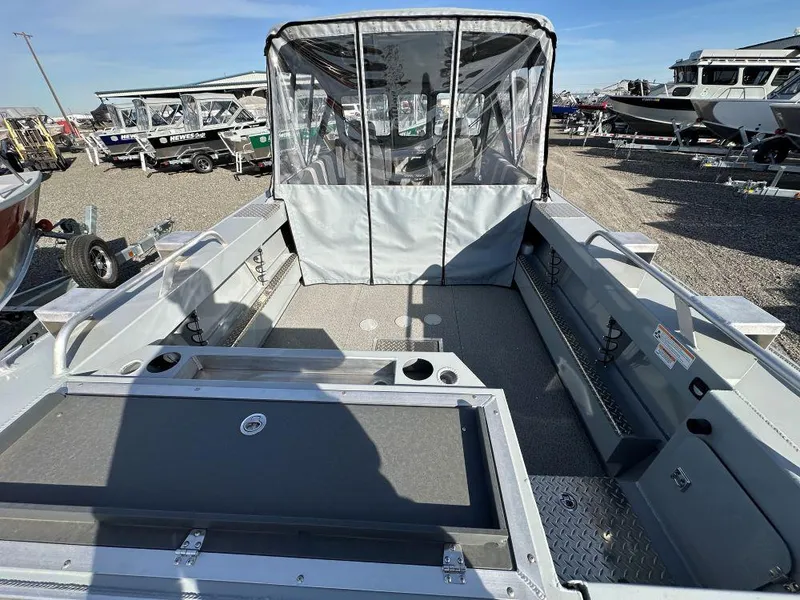Slide: The Image of 2025 Hewescraft 210 Sea Runner ET boat interior with canopy, parked outdoors. - 4