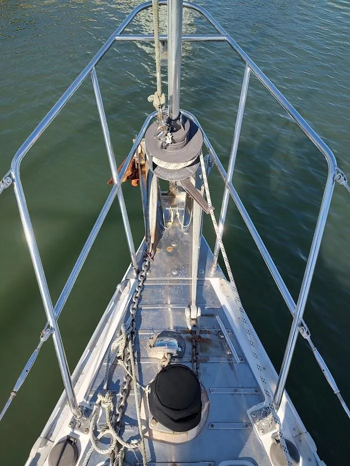 Slide: The Image of Bow of a 1997 Hylas 46 sailboat with anchor and railing over water. - 11