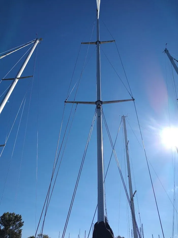 Slide: The Image of Tall sailboat masts against a clear blue sky, Hylas 46, 1997 model. - 12