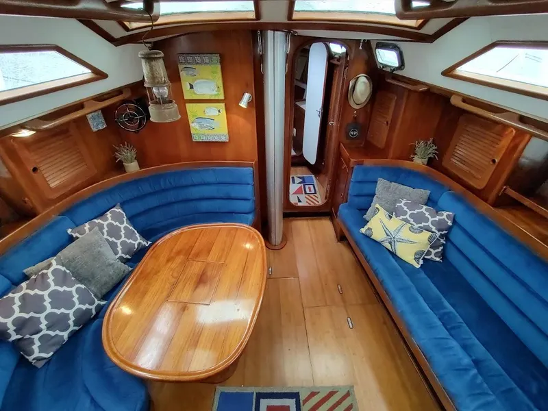 Slide: The Image of Interior of a 1997 Hylas 46 yacht with blue seating and wooden table. - 27