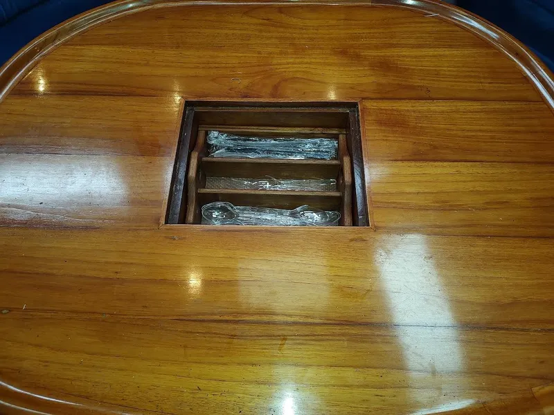 Slide: The Image of Wooden table with built-in cutlery storage on a 1997 Hylas 46 yacht. - 32