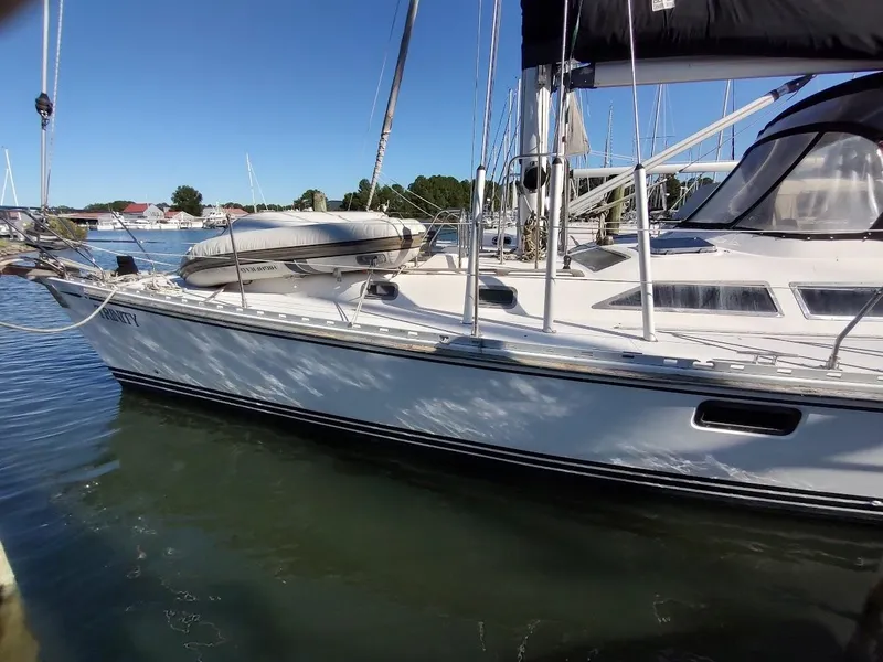 Slide: The Image of Sailboat Hylas 46, 1997 model, docked in a marina under clear blue skies. - 4