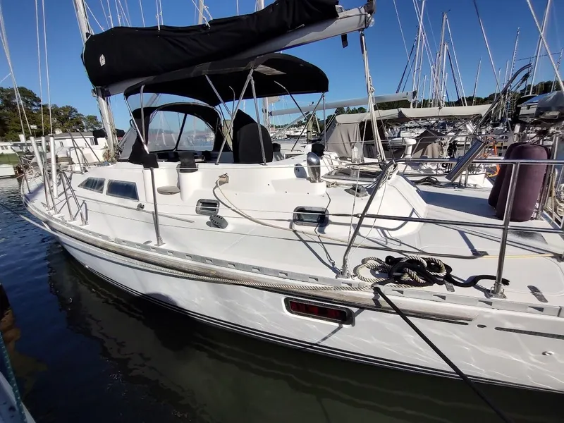 Slide: The Image of Sailboat Hylas 46, 1997 model, docked in a marina under clear blue sky. - 5