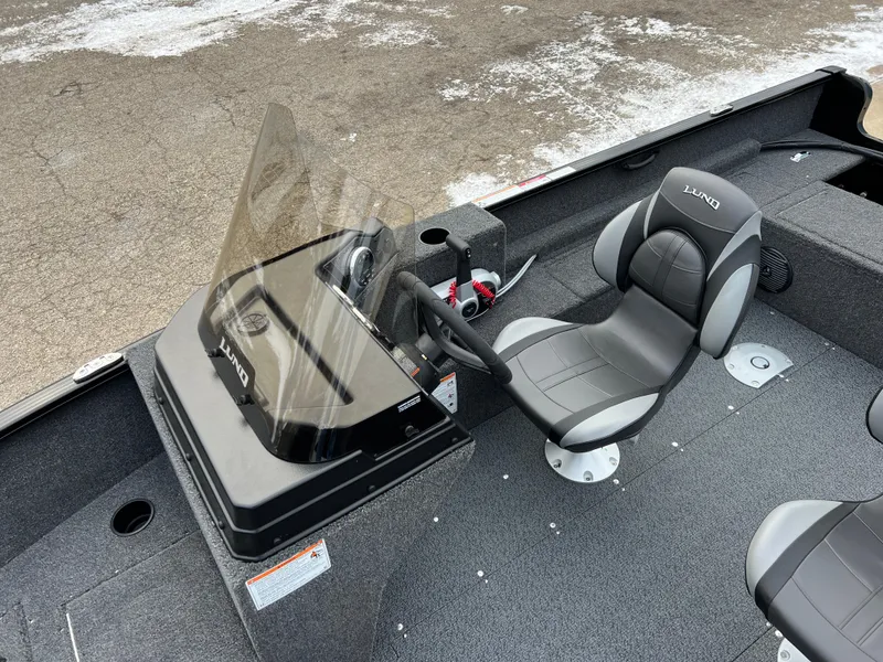 Slide: The Image of 2025 Lund 1650 Rebel XL SS Blackout boat interior with steering console and seat. - 11