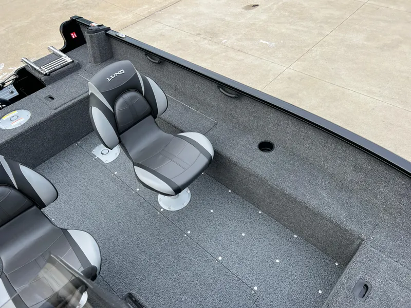 Slide: The Image of 2025 Lund 1650 Rebel XL SS Blackout boat interior with gray seating and carpeted floor. - 12