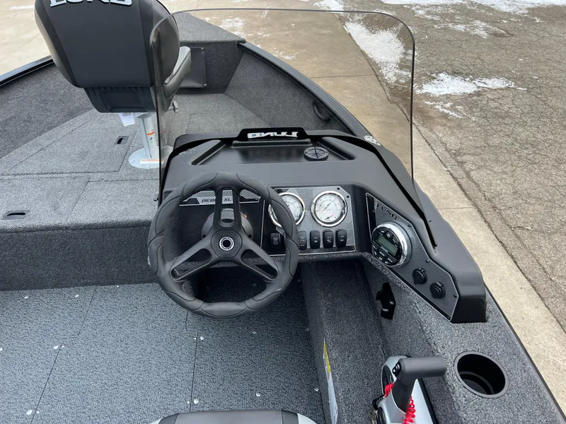 Slide: The Image of 2025 Lund 1650 Rebel XL SS Blackout boat interior with steering wheel and dashboard controls. - 16