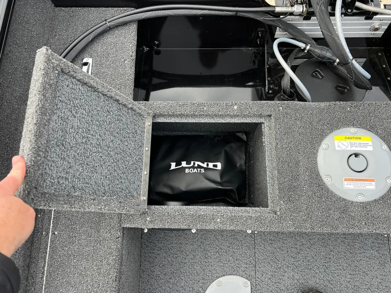 Slide: The Image of 2025 Lund 1650 Rebel XL SS Blackout boat storage compartment with logo. - 20