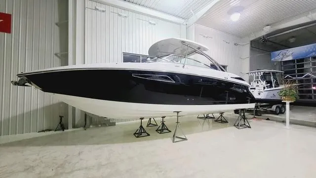 Slide: The Image of 2022 Cobalt R35 boat in showroom, sleek black and white design. - 1