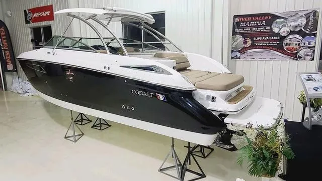 Slide: The Image of 2022 Cobalt R35 boat displayed indoors on stands. - 2