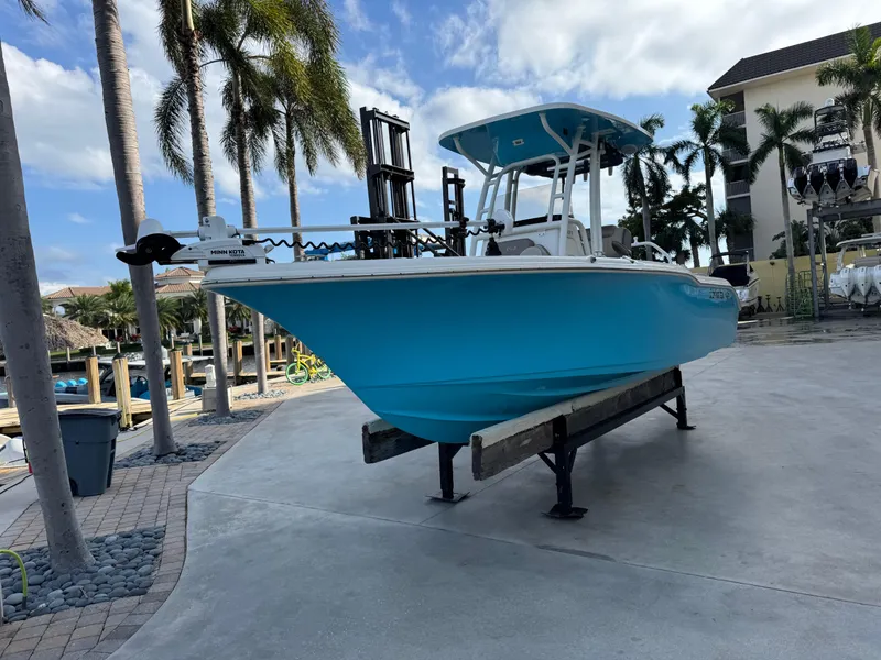 The Image of 2024 Key West 239 FS boat on display, vibrant blue hull, palm trees in background. - 0