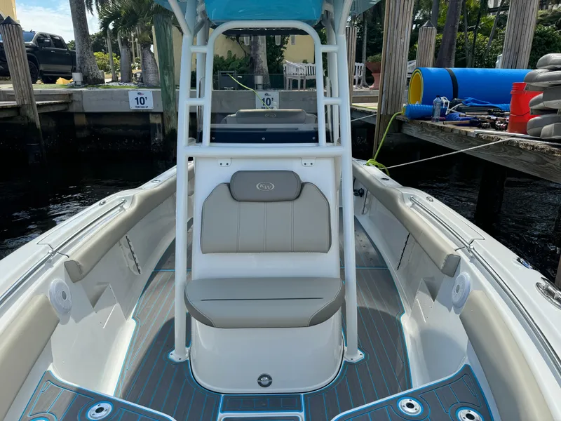 Slide: The Image of 2024 Key West 239 FS boat interior with seating and console, docked by the water. - 13