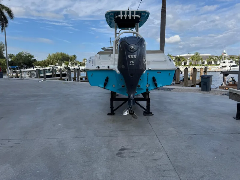 Slide: The Image of 2024 Key West 239 FS boat with 300 V6 engine at a marina dock. - 2