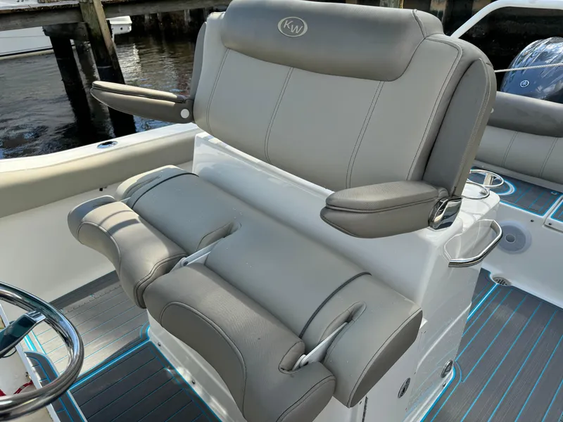 Slide: The Image of 2024 Key West 239 FS boat seat, gray leather, modern design, docked by water. - 21