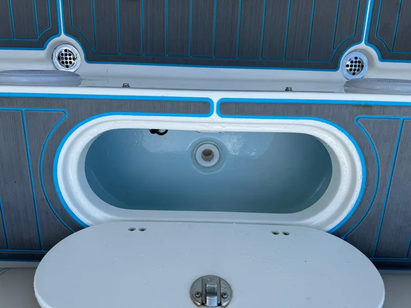 Slide: The Image of 2024 Key West 239 FS boat livewell with open lid, blue accents, and modern design. - 26