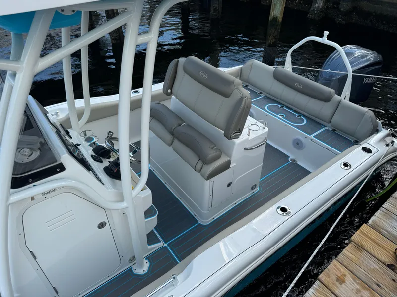 Slide: The Image of 2024 Key West 239 FS boat interior with seating and console, docked by the water. - 7