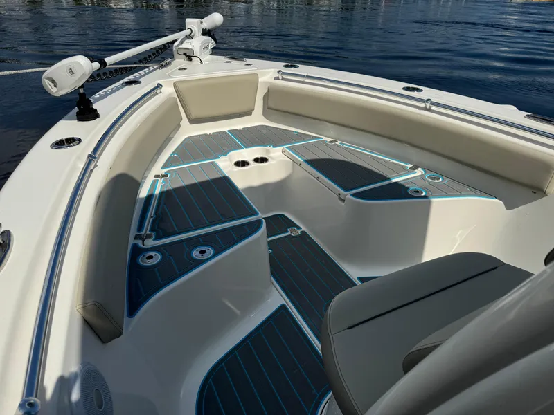 Slide: The Image of 2024 Key West 239 FS boat interior with cushioned seating and sleek design on calm water. - 9
