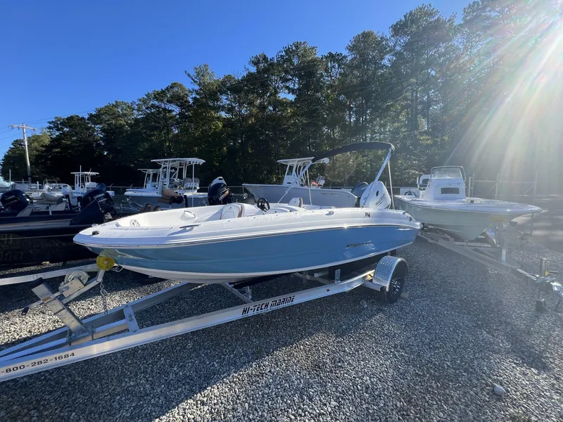 Slide: The Image of 2025 Stingray SC 182SC boat on trailer, parked outdoors under sunlight. - 2