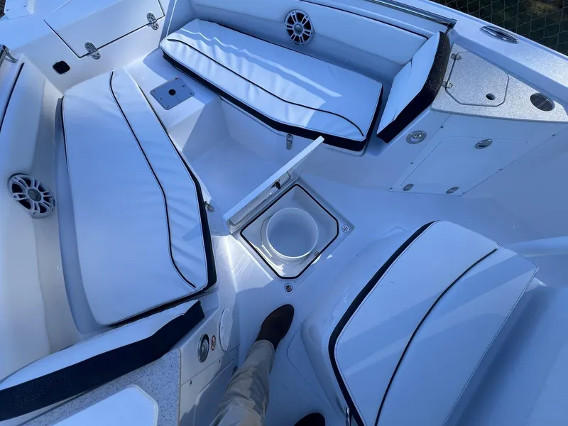 Slide: The Image of 2025 Stingray CC 216 CC boat interior with white cushioned seating and storage compartments. - 11