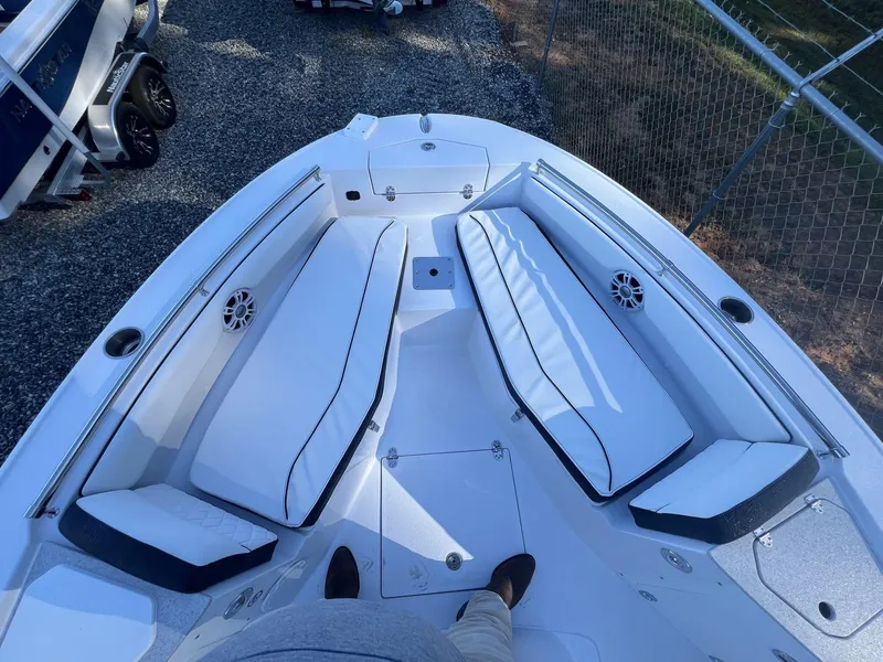 Slide: The Image of 2025 Stingray CC 216 CC boat interior with white cushioned seating and speakers. - 14