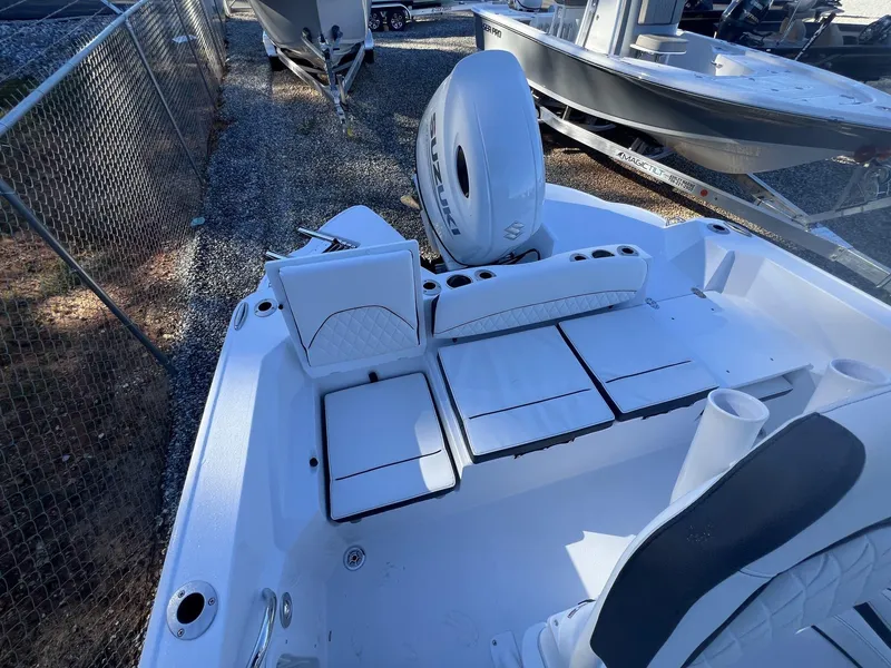 Slide: The Image of 2025 Stingray CC 216 CC boat interior with white seating and Suzuki outboard motor. - 4