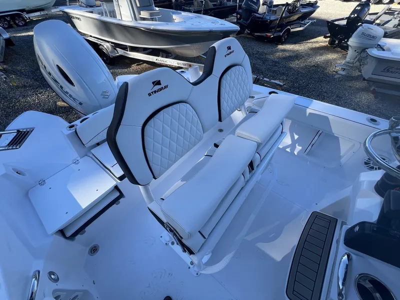 Slide: The Image of 2025 Stingray CC 216 CC boat interior with white seating and Suzuki outboard motor. - 6
