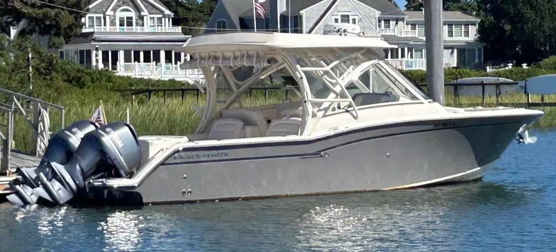 Slide: The Image of 2018 Grady-White Freedom 325 boat docked near waterfront homes. - 2