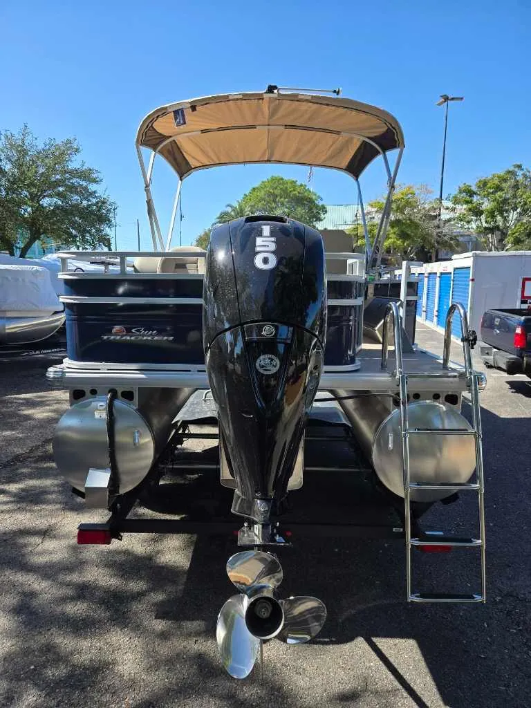 Slide: The Image of 2025 Sun Tracker Fishin' Barge 22 DLX with 150 HP engine, parked outdoors. - 3