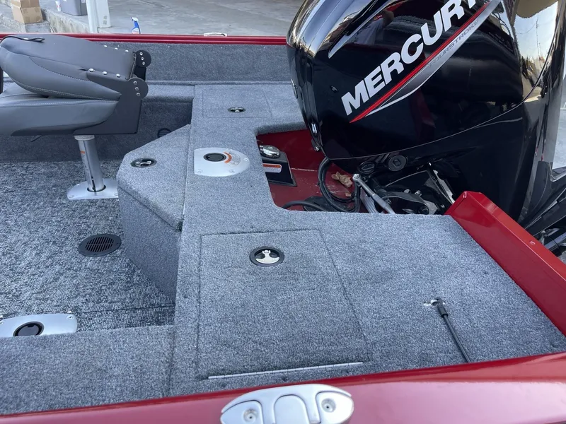 Slide: The Image of 2025 Tracker Pro Guide V-16 WT boat interior with Mercury engine, gray carpet, and seating. - 4