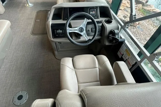 Slide: The Image of 2025 Sun Tracker Sportfish 24 XP3 boat interior with steering wheel and beige seating. - 5